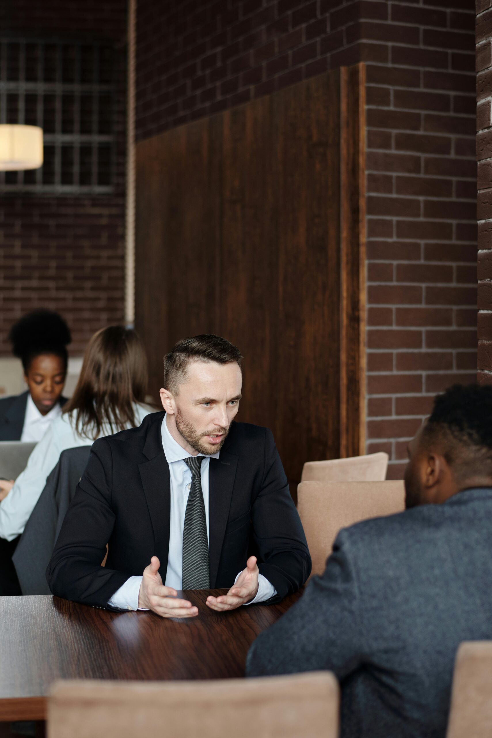 Professionals in suits having a focused business discussion in a stylish café.